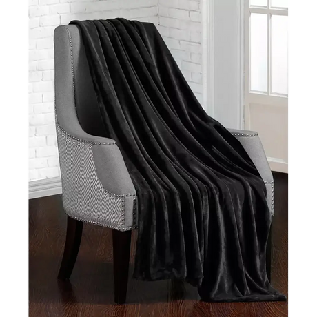 Plush weighted blanket draped over gray upholstered accent chair in cozy living room