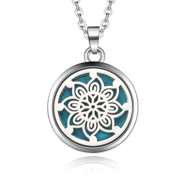 Silver necklace diffuser pendant with snowflake floral design on turquoise background