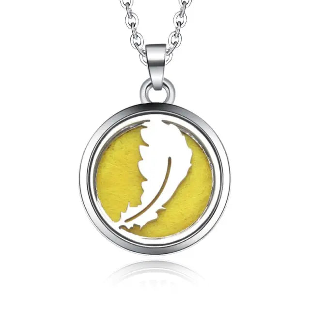 Silver necklace diffuser pendant with white feather design on yellow background