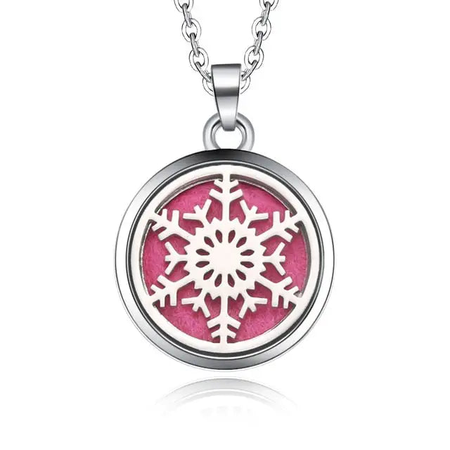 Silver necklace diffuser pendant with white snowflake design on pink background