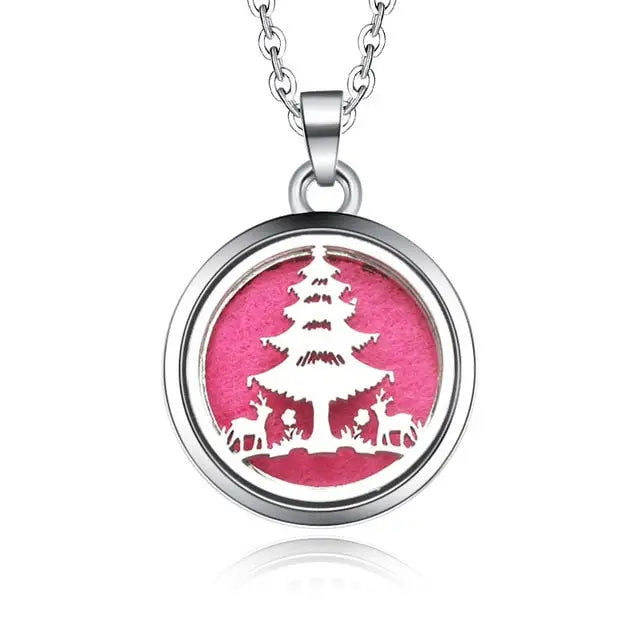 Silver necklace diffuser pendant with Christmas tree and deer silhouette on pink background