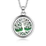 Silver necklace diffuser pendant with tree of life design on green background