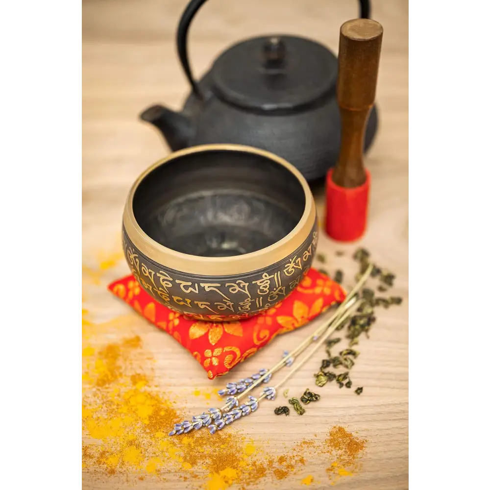 Tibetan singing bowl with ornate carvings and Sanskrit inscriptions in a set