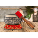 Authentic Tibetan Singing Bowl with Sanskrit Inscriptions on red cushion and wooden striker