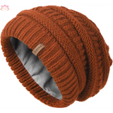 Rust-colored slouchy winter hat knit beanie with ribbed pattern and fleece lining