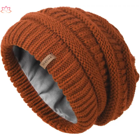 Rust-colored slouchy winter hat knit beanie with ribbed pattern and fleece lining