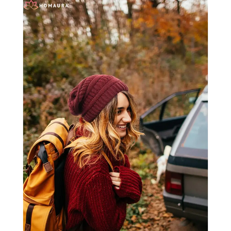 Person in burgundy knit beanie and sweater with yellow backpack, showcasing a slouchy winter hat