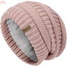 Pink knitted slouchy winter hat featuring textured pattern and small brand label