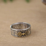 Ornate sterling silver Buddha Mantra ring with decorative scrollwork and gold accent