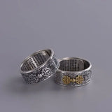 Two ornate sterling silver rings featuring floral patterns and Buddha Mantra symbols