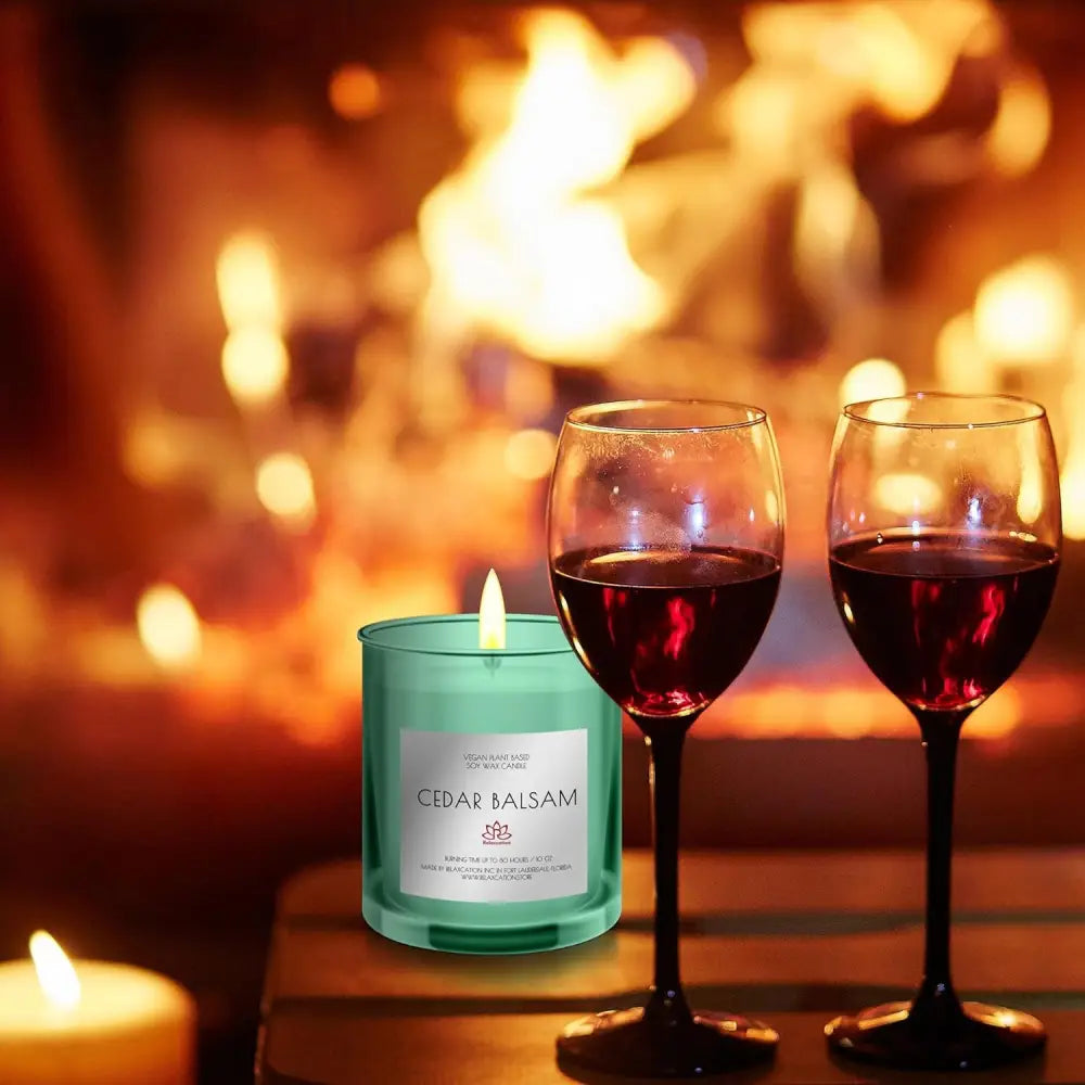 Two glasses of red wine and a Cedar Balsam scented soy candle in green glass