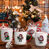 White ceramic Christmas mugs set featuring Santa Claus designs and red trim