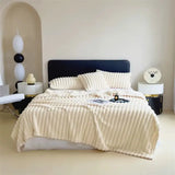 Cream-colored faux rabbit fur ribbed bedding set on navy headboard bed