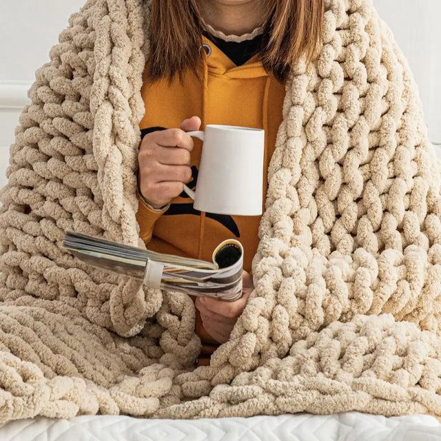 Cozy Oat White Chunky Knit Blanket throw in soft chenille yarn with coffee mug