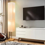 Modern white media console with tapered legs next to a stylish LED floor lamp