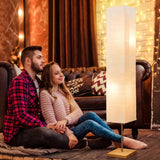 Couple in cozy winter clothing beside Dimmable LED Floor Lamp with Wooden Base