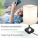 Modern dimmable USB bedside table lamp with white shade and black base, features charging ports