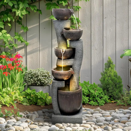 Tiered water fountain with illuminated bowls on stone-textured column for indoor outdoor use