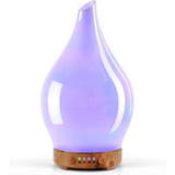 Teardrop-shaped purple glass aromatherapy oil diffuser with wooden base and LED lights