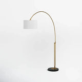 Curved brass Elegant Joan Arched Floor Lamp with white drum shade and black base