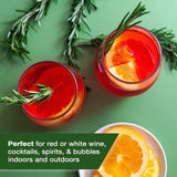 Red cocktails in elegant stemless wine glasses garnished with rosemary and orange slices