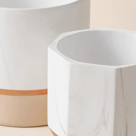 Elegant White Ceramic Planters with Rose Gold Accents and Terracotta Base on display