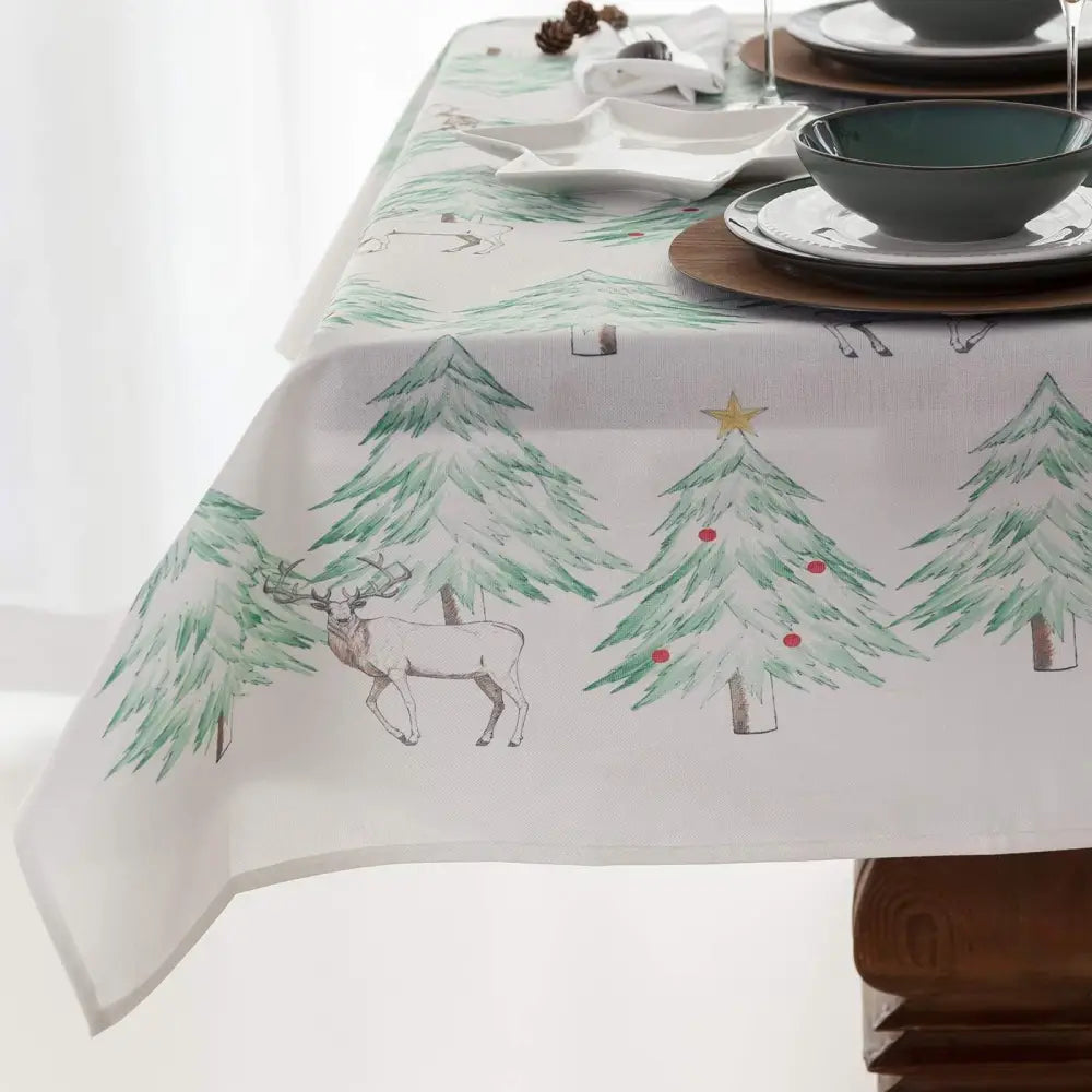 White Christmas tablecloth with painted green trees and reindeer for festive gatherings