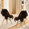 Two modern chairs with black faux sheepskin fur covers beside a fluffy long pile rug