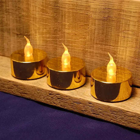 Gold LED tea lights with flickering flames and red berry branches for elegant decor