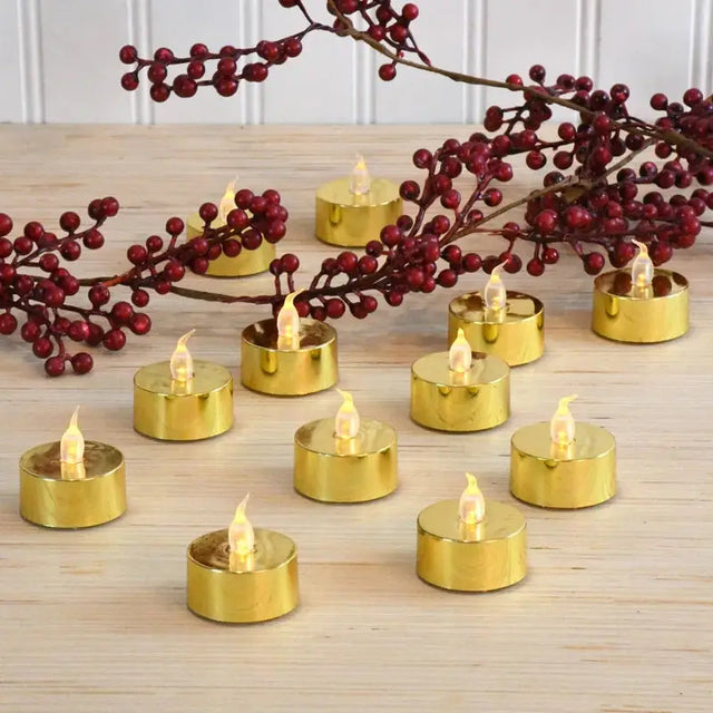 Gold LED tea lights elegantly arranged with red berry branches for festive decor