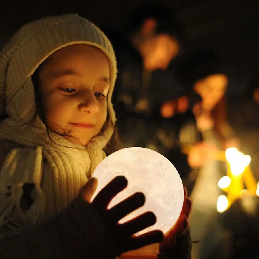 Silhouetted fingers hold a glowing white orb, showcasing the GoodNight Moon Lamp Night Light