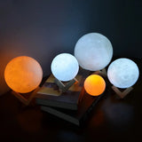 Illuminated GoodNight Moon Lamp night light glowing in white and orange on stands