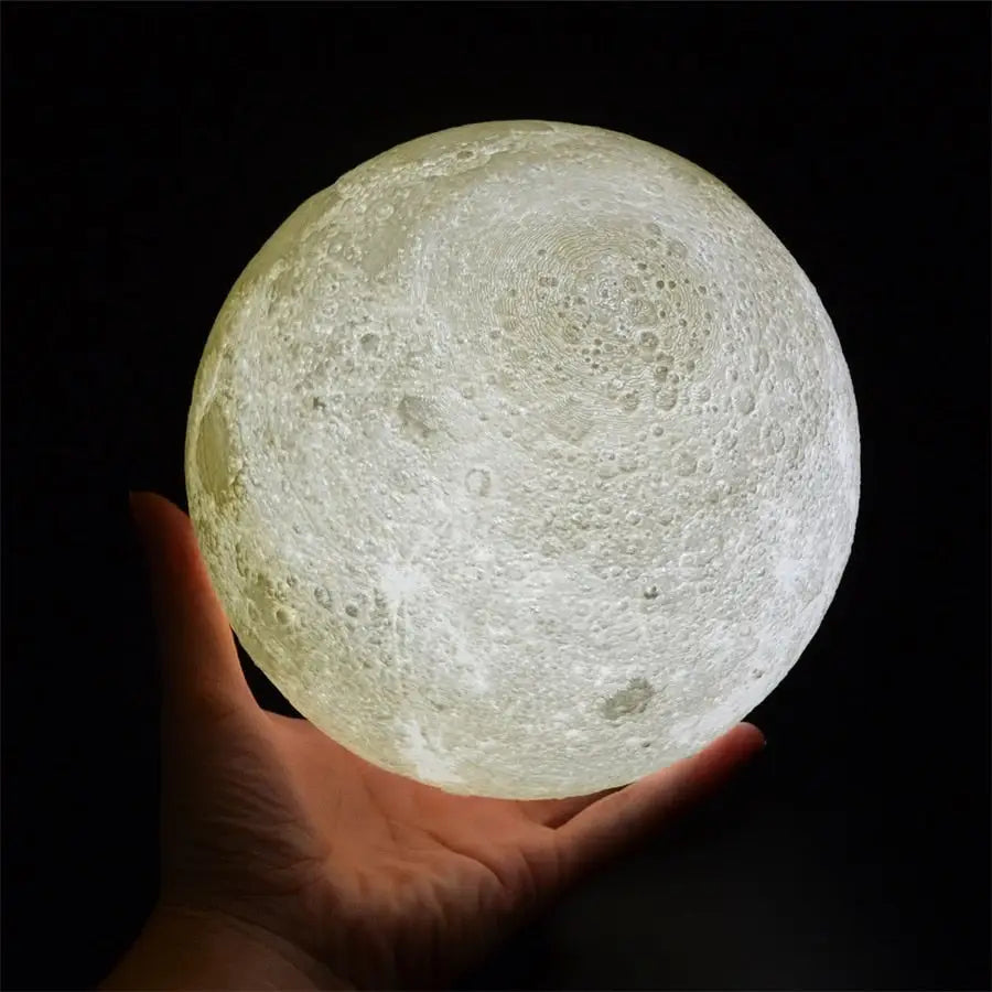 Glowing GoodNight Moon Lamp night light held in a hand, creating a serene ambiance