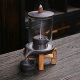 Glass-enclosed handmade ceramic incense burner with wooden stand and ceramic lid