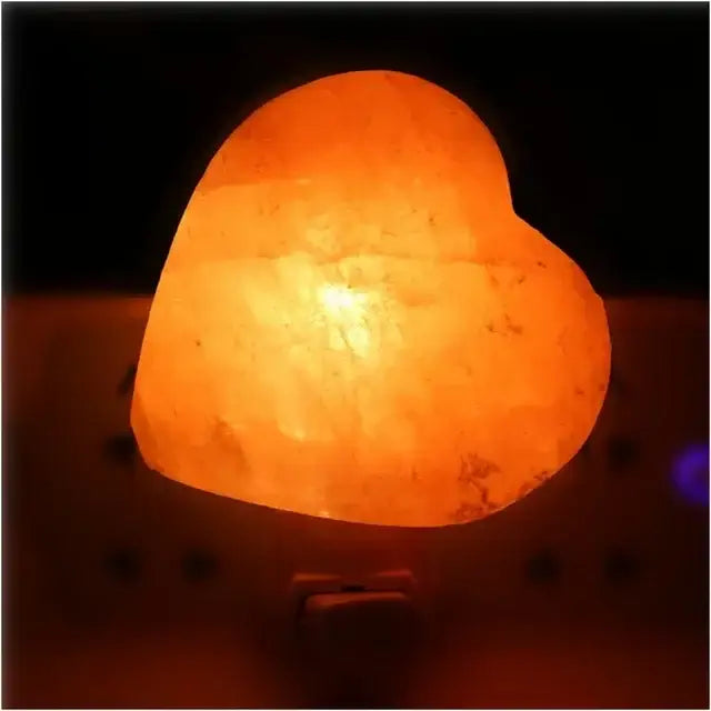 Heart-shaped Himalayan salt lamp emitting warm white glow for cozy ambiance