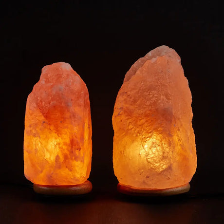 Two glowing Himalayan salt lamps radiating warm orange light in a cozy setting