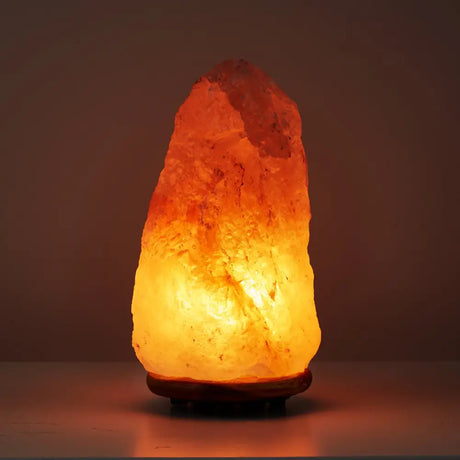 Glowing Himalayan salt lamp emitting warm orange light from Himalayan Shop Natural Pink Salt Lamp