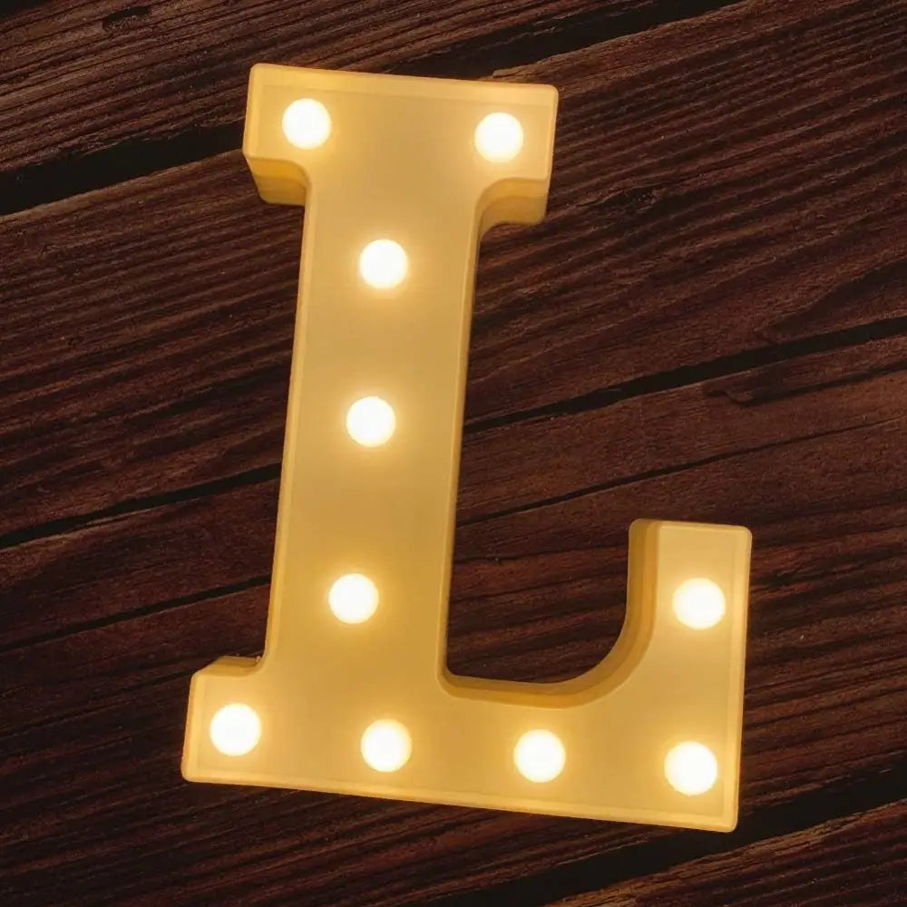 Illuminated marquee letter L with glowing light bulbs for birthday celebrations