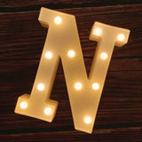 Illuminated marquee letter N with glowing light bulbs for birthday celebrations