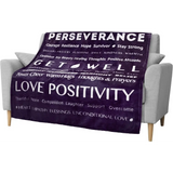 Purple upholstered armchair with inspirational words, next to Healing Fleece Blanket