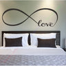 Infinity vinyl decal of the word love mounted above a bed as stylish wall art