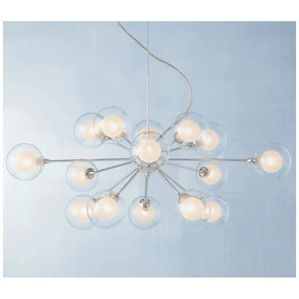 Modern starburst chrome chandelier with frosted glass globes above mid century dining set