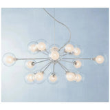 Modern starburst chrome chandelier with frosted glass globes above mid century dining set