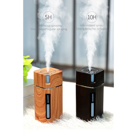 Two portable essential oil diffusers with wood grain and black finishes emitting steam