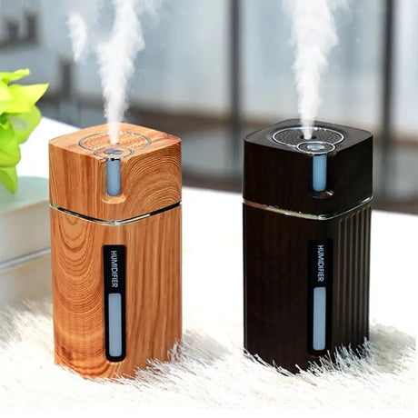 Portable USB essential oil diffusers with wood grain and black finishes emitting steam