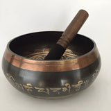 Tibetan singing bowl with wooden striker and Sanskrit inscriptions in Himalayan hand-hammered design