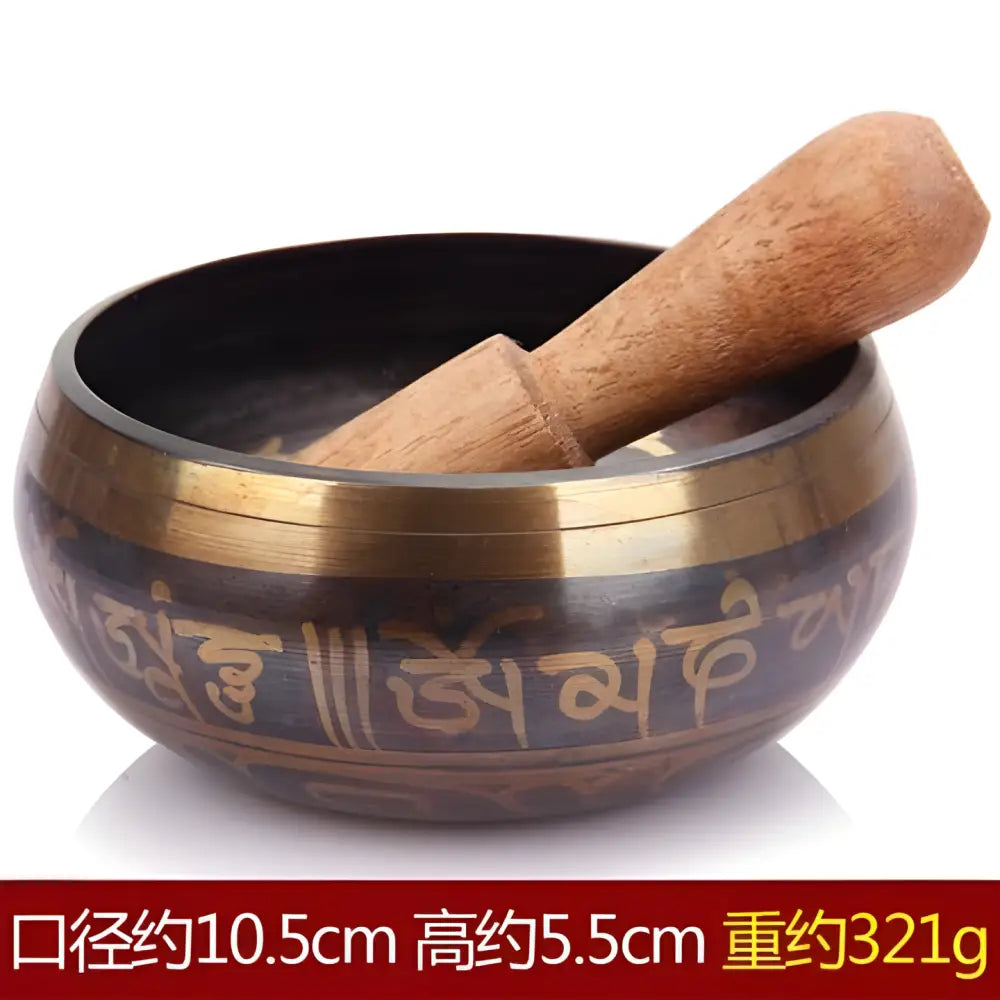 Tibetan singing bowl with wooden striker and ornate carved Sanskrit text design