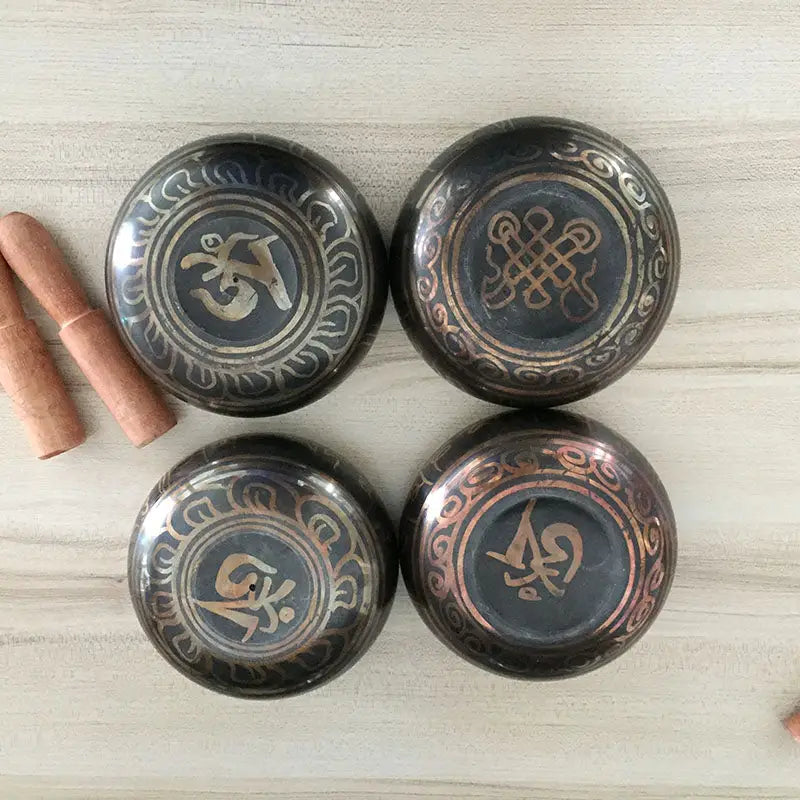 Four Himalayan hand-hammered Tibetan singing bowls with ornate etched designs