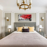 Elegantly styled bed with gray headboard and pillows near Red Moon Tree Canvas Wall Art