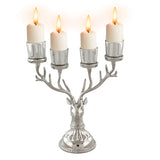 Silver reindeer candle holder with four lit white candles for festive holiday decor